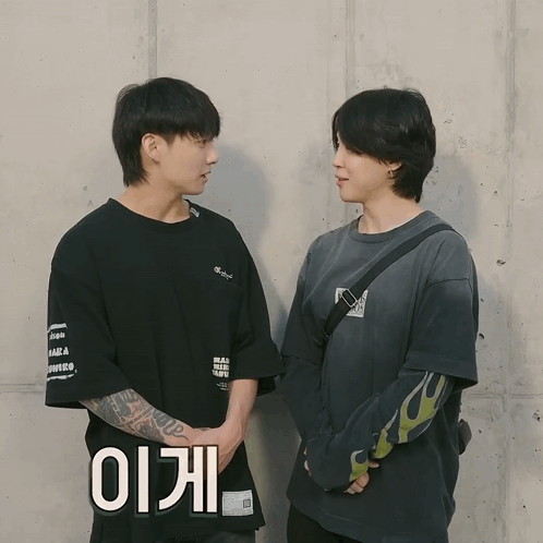 two young men standing next to each other with one wearing a black shirt that says ' ii ' on it