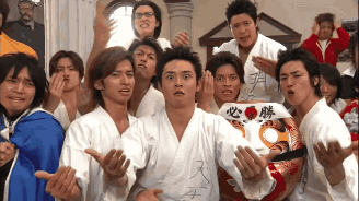 a group of young men are posing for a picture and one of them is wearing a shirt with chinese characters