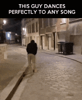a man is walking down a cobblestone street at night and the caption says this guy dances perfectly to any song