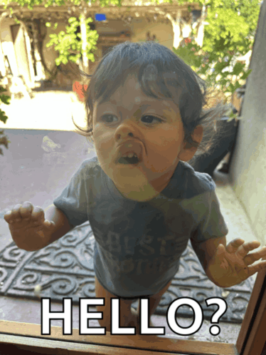 a baby looking through a window with the words hello written on it