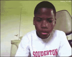 A seated person stares downward with “SHUTTERTON” text on their shirt.