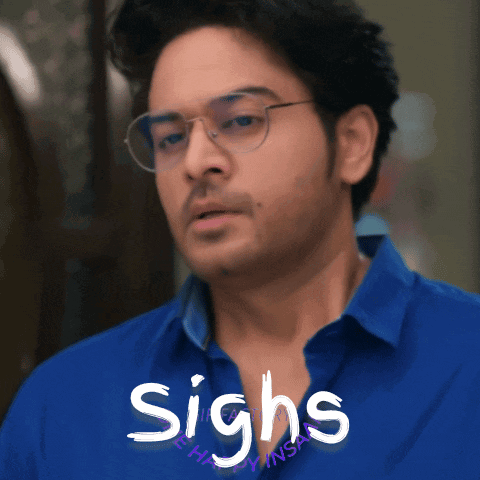 a man wearing glasses and a blue shirt has the word sighs written in white