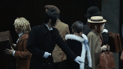 a group of people dressed in costumes are standing in a row