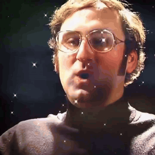 a close up of a man wearing glasses and a turtleneck sweater
