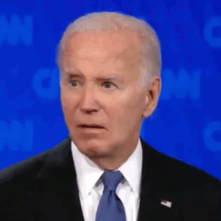 joe biden is wearing a suit and tie and making a funny face .