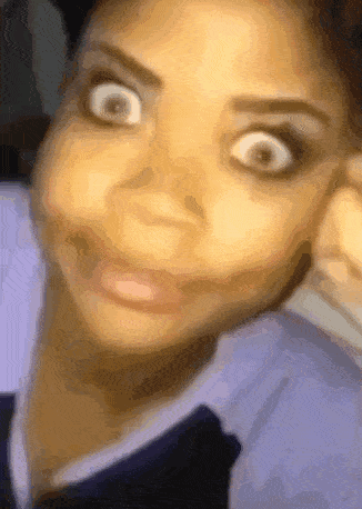 A woman stares at the camera with comically widened eyes.