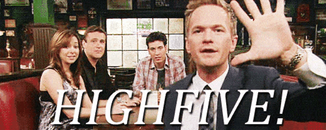 A man holds up his palm in front of a group photo with the words “HIGH FIVE!”