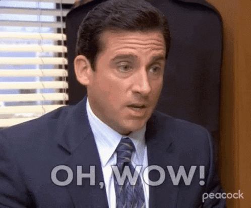 A man in an office looks stunned beneath a large “OH, WOW!” caption.