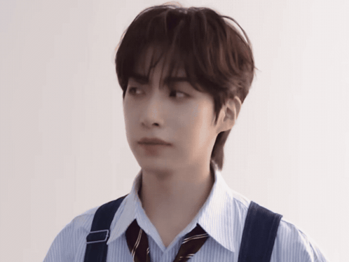 a young man wearing a striped shirt and suspenders