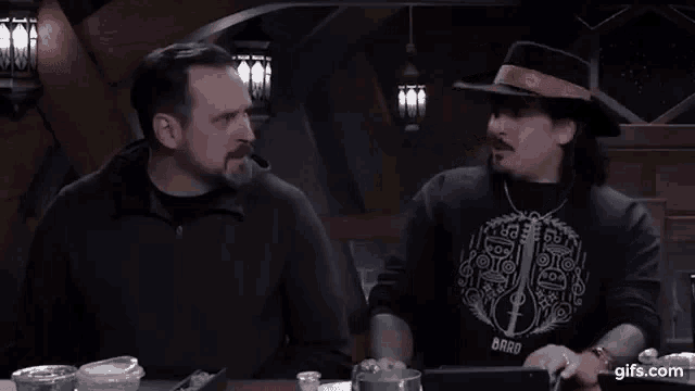 two men are sitting at a table talking to each other and one of them is asking why is you so mean to me .