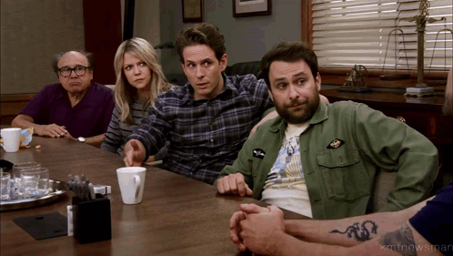 a group of people are sitting around a table and one of them has a tattoo of a dragon