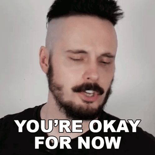 a man with a beard is making a funny face and says you 're okay for now .