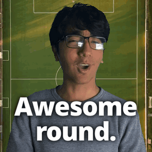 a man with glasses says awesome round in front of a green field