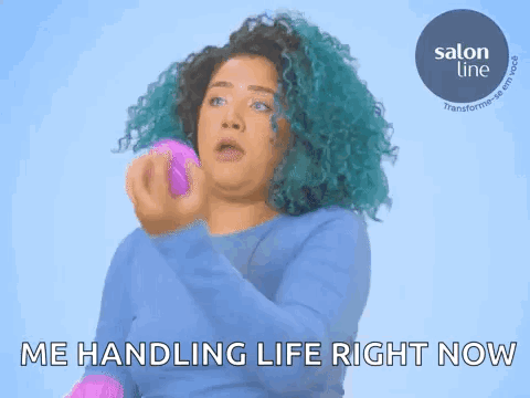 a woman with blue hair is holding a pink object in her hand .