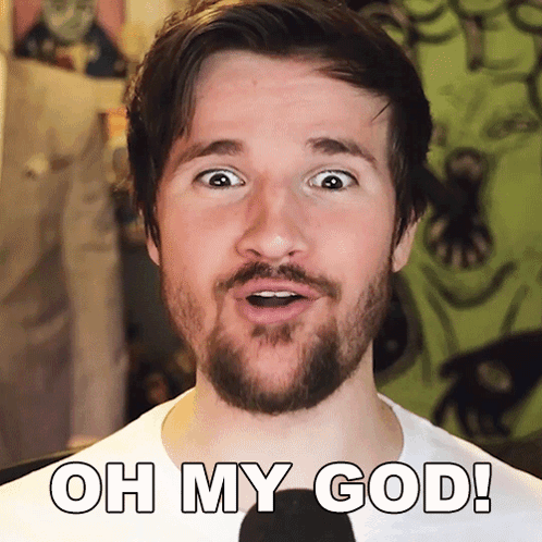 a man with a beard says " oh my god " in front of a microphone