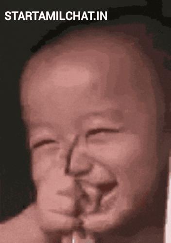 A baby laughs with eyes nearly closed in a vertical video.