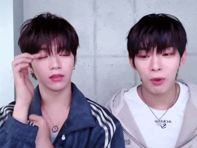two young men are standing next to each other and one of them has a necklace that says ' adidas ' on it