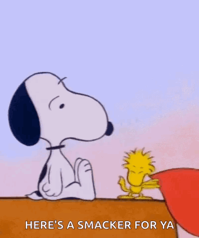 Snoopy and Woodstock sit together with a caption reading “HERE’S A SMACKER FOR YA.”