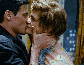 a man is kissing a woman on the neck in a blurry photo