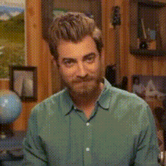 a man with a beard is wearing a green shirt and smiling