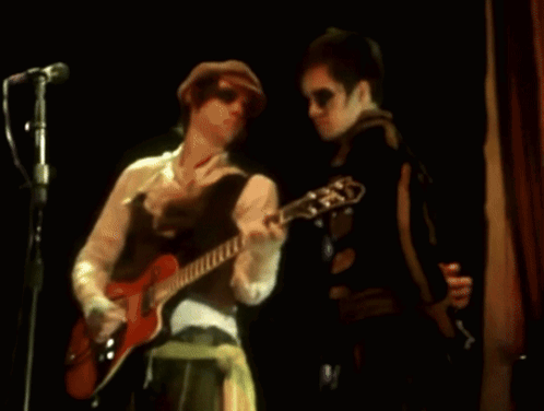 a blurry image of a man playing a guitar and singing into a microphone