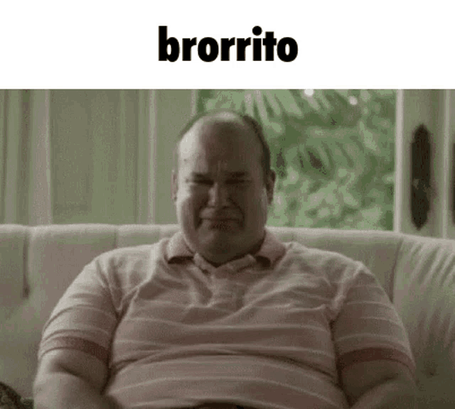a fat man is sitting on a couch with his mouth open .