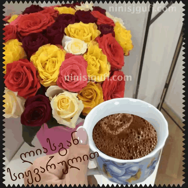 a person holding a cup of coffee next to a bouquet of flowers