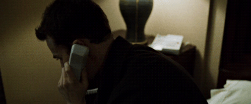 a man in a black shirt is talking on a phone