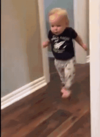 A toddler runs down a hallway in a home.