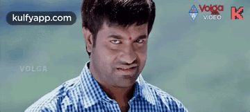 a man in a blue and white checkered shirt is smiling with his eyes closed in a video .