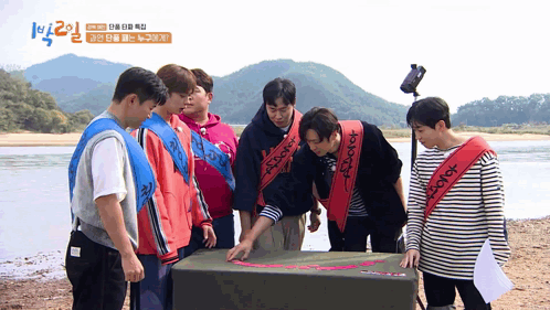 a group of young men are standing around a box with a sticker on it that says " explorer "