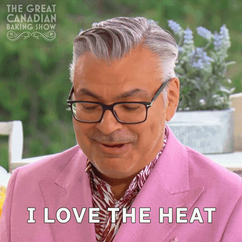 a man wearing glasses and a pink suit is saying i love the heat