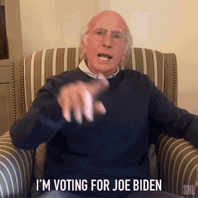 a man sitting in a chair with the words i 'm voting for joe biden below him