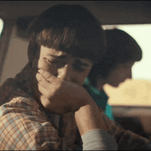 Will from Stranger Things cries while seated in a vehicle.