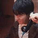 A man holds a phone to his ear and laughs.